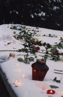 Flowers and burning candles at the mound of ashes to commemorate the victims.